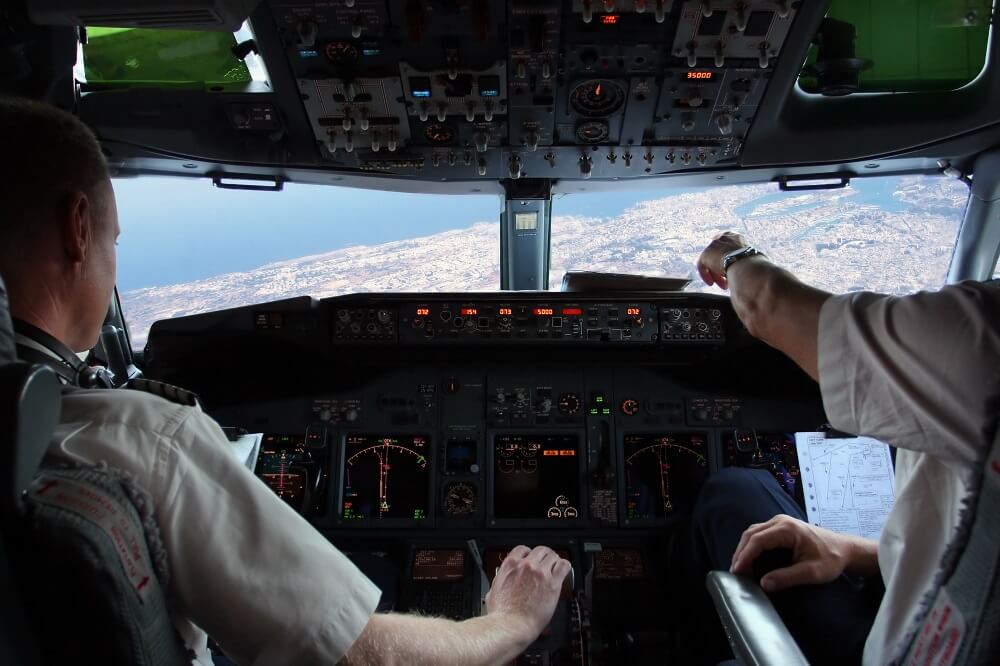 Zwei Piloten im Cockpit eines Flugzeugs im Landeanflug