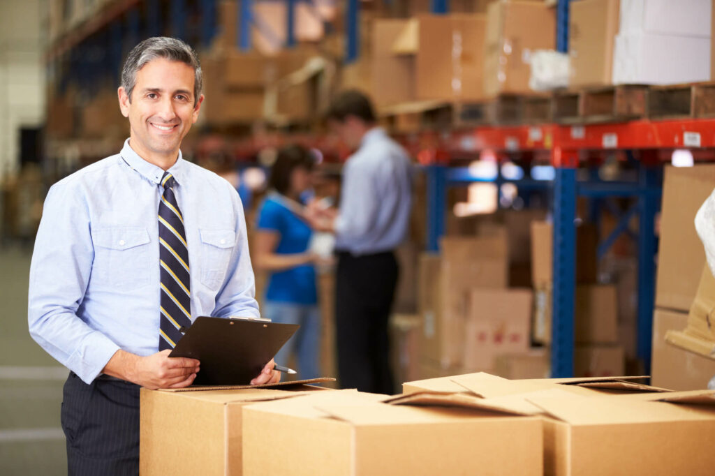 A managing director of a mid-sized company checks the goods in the warehouse