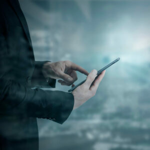 Ein Mann im Anzug lädt auf seinem mobilen Gerät ein Dokument eines Top ERP Anbieters herunter